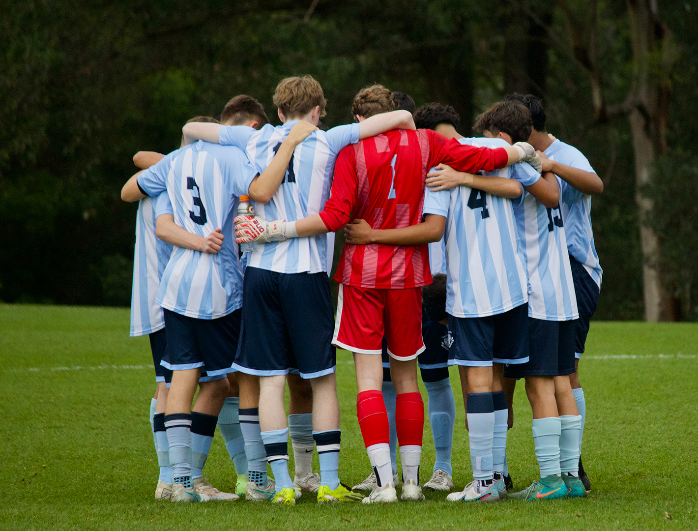 Football players arm in arm before a match